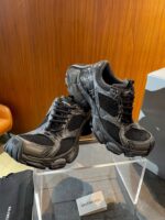 Scarpe Balenciaga nere in mesh, design moderno e dettaglio di alta moda nel showroom.