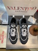 Sneakers Valentino Garavani neri e bianchi di alta moda, logo distintivo e design elegante.