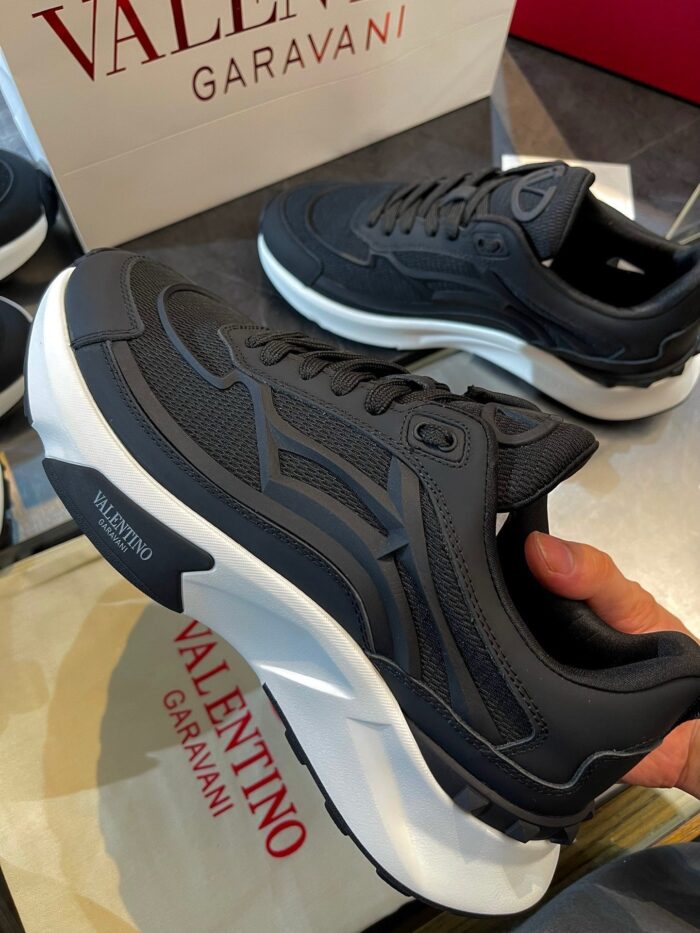 Sneakers Valentino Garavani in grigio scuro con suola bianca, stile moderno e design elegante.