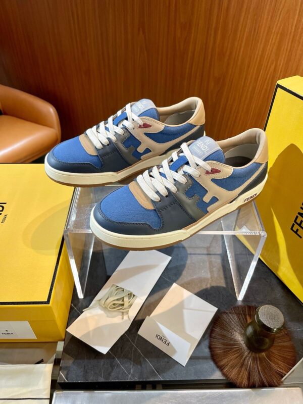 Sneaker retrò in blu e beige su stand di vetro in ambiente elegante e raffinato.