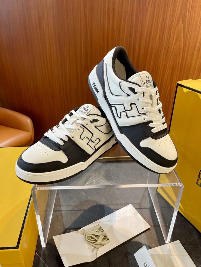 Sneakers moderne nere e bianche esposte in showroom con design elegante e logo distintivo.
