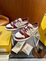 Sneakers Fendi bianche e bordeaux su espositore di lusso con scatole brandizzate.