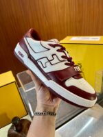 Sneaker bianca e bordeaux in esposizione, stile moderno e dettagli artigianali.