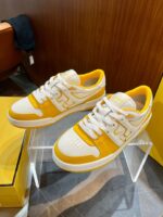 Sneakers sportive bianche con dettagli gialli eleganti e tessuto traspirante, ideali per sport e casual.