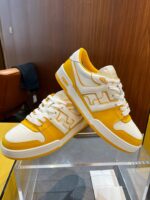 Scarpe da ginnastica gialle e bianche, stile sportivo e confortevole, in negozio moderno.