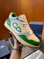 Sneaker di lusso bianca e verde con logo oversize, design elegante e dettagli di alta qualità.