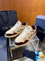 Sneakers Dior eleganti con dettagli cream e burgundy, packaging di lusso e design sofisticato.
