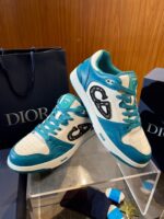 Sneakers Dior color teal e bianco in stile luxury con dettaglio artistico e materiali di alta qualità.