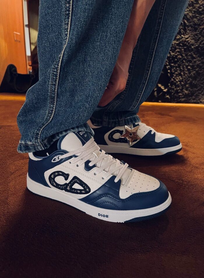 Scarpe da ginnastica blu e bianca con jeans casual in stile streetwear indoor.