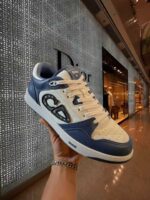 Sneaker moderna bianca e navy con design distintivo e dettagli premium in ambiente di lusso.