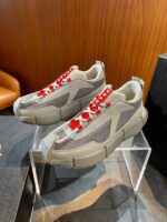 Sneaker moderne con lacci rossi e suola spessa in raffinato spazio retail urbano.