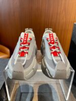 Sneakers Prada moderne con lacci rossi, design elegante e dettagli di alta qualità.