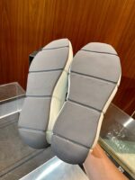Sole di sneaker in gomma grigia, resistente, con grip e dettagli flessibili per uso quotidiano.