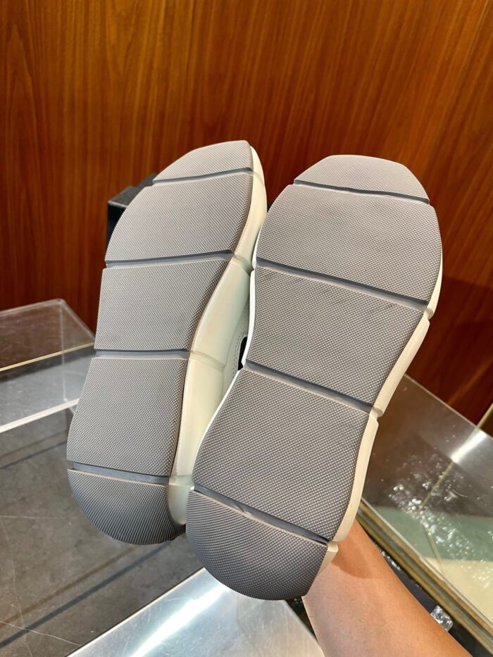 Sole di sneaker in gomma grigia, resistente, con grip e dettagli flessibili per uso quotidiano.