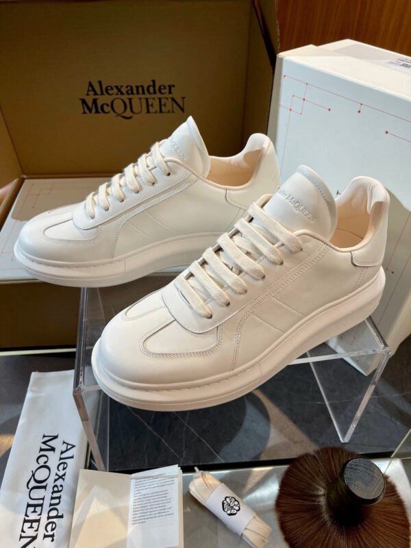 Scarpe sneakers di lusso Alexander McQueen bianche con design moderno e dettagli curati, in esposizione elegante.