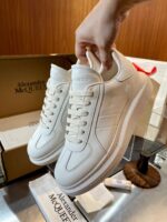 Scarpe da ginnastica bianche di lusso Alexander McQueen, stile moderno e design elegante in boutique.