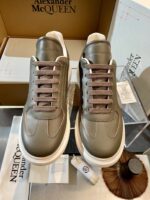 Sneakers Alexander McQueen grigio, stile moderno, suola bianca chunky, dettagli di alta qualità.