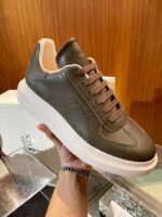 Sneaker moderna in verde oliva con suola bianca, stile elegante e design versatile.
