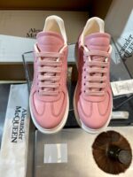 Sneakers rosa di lusso Alexander McQueen, stile moderno e raffinato, confezione esclusiva e dettagli eleganti.