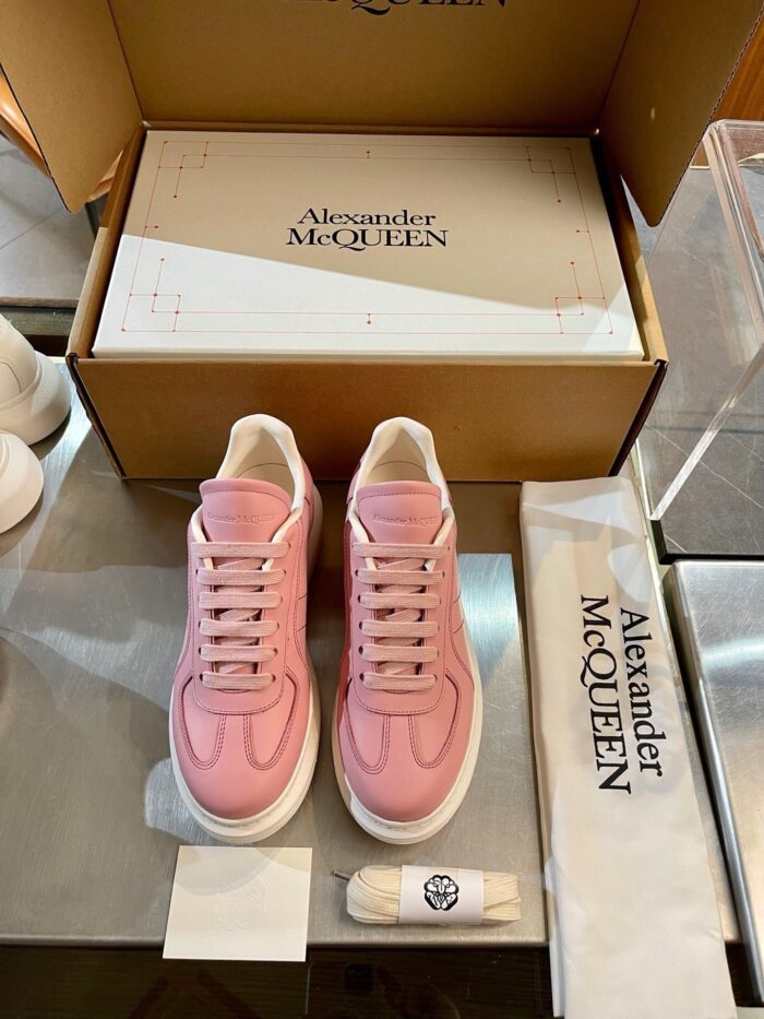 Sneakers rosa di lusso Alexander McQueen con scatola elegante e dettagli raffinati.