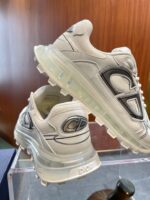 Sneakers bianche moderne con suola trasparente, logo audace e design elegante, perfette per stile e comfort.