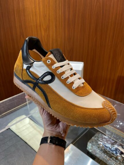 Sneaker moderna bianca e arancione con dettagli neri su sfondo raffinato e riflettente.