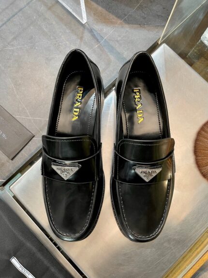 Scarpe Prada loafer nere in pelle lucida, elegante e di alta qualità, perfette per ogni occasione.