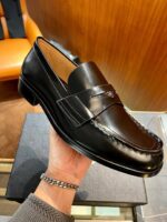 Mocassino in pelle nera di lusso, elegante e artigianale, perfetto per look raffinati e sofisticati.