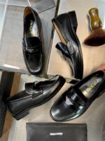Loafer in pelle nera con accessori di lusso: scarpe eleganti e accessori raffinati.