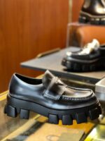 Scarpa loafer in pelle nera con suola chunky moderna, elegante e ideale per uno stile sofisticato.