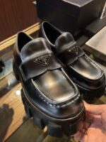 Mocassini di lusso con suola piattaforma, stile elegante e moderno in pelle nera lucida.