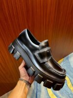 Scarpe loafer chunky in pelle nera con suola piatta, stile moderno e sofisticato.
