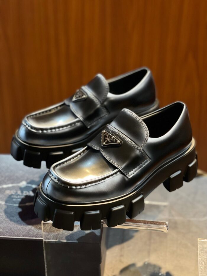 Sneakers Prada di lusso con suola chunky in pelle nera e dettagli logo elegante.