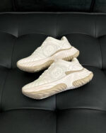 Scarpe sportive bianche moderne su superficie nera, design elegante e traspirante per attività fisica.