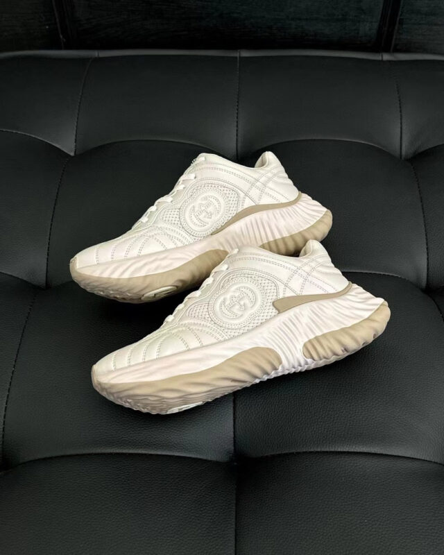 Scarpe sportive bianche moderne su superficie nera, design elegante e traspirante per attività fisica.