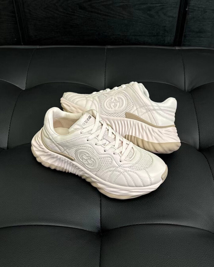 Sneakers bianche moderne su divano nero, stile casual e comfort urbano.