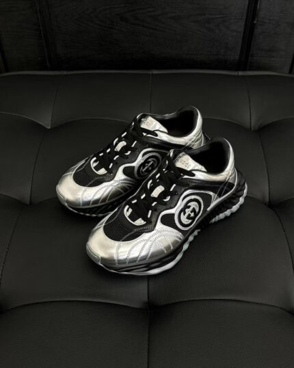 Scarpe sportive futuristiche nere e argento con design moderno e dettagli performance.