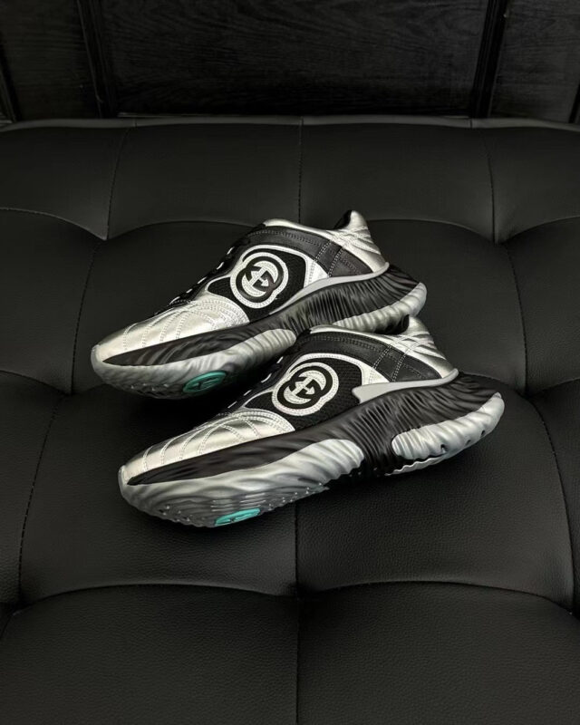 Sneakers moderne con logo circolare, dettagli colorati e design elegante su superficie nera.