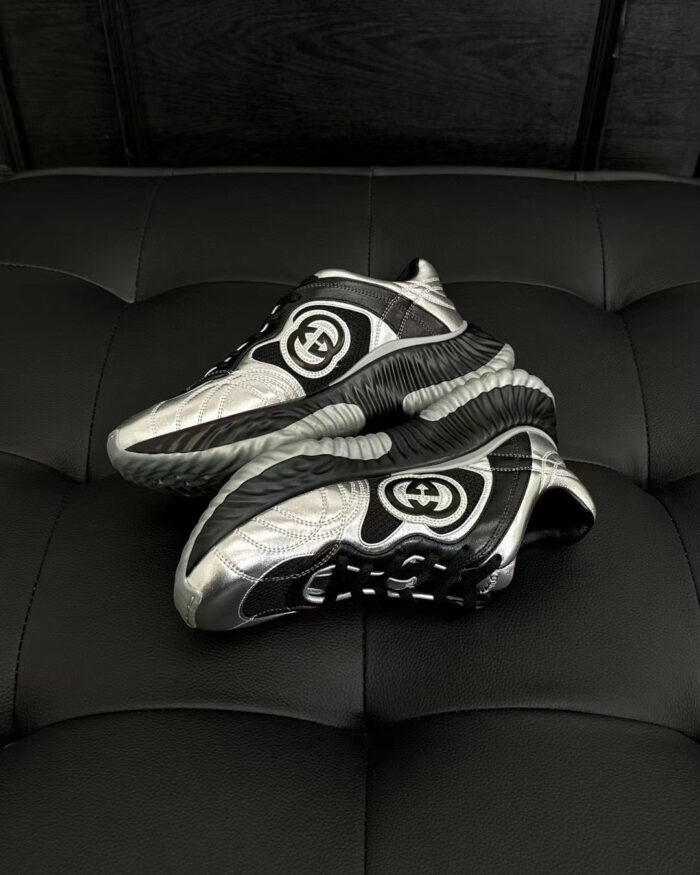 Sneaker moderna in argento e nero su superficie nera elegante, perfetta per stile e active lifestyle.