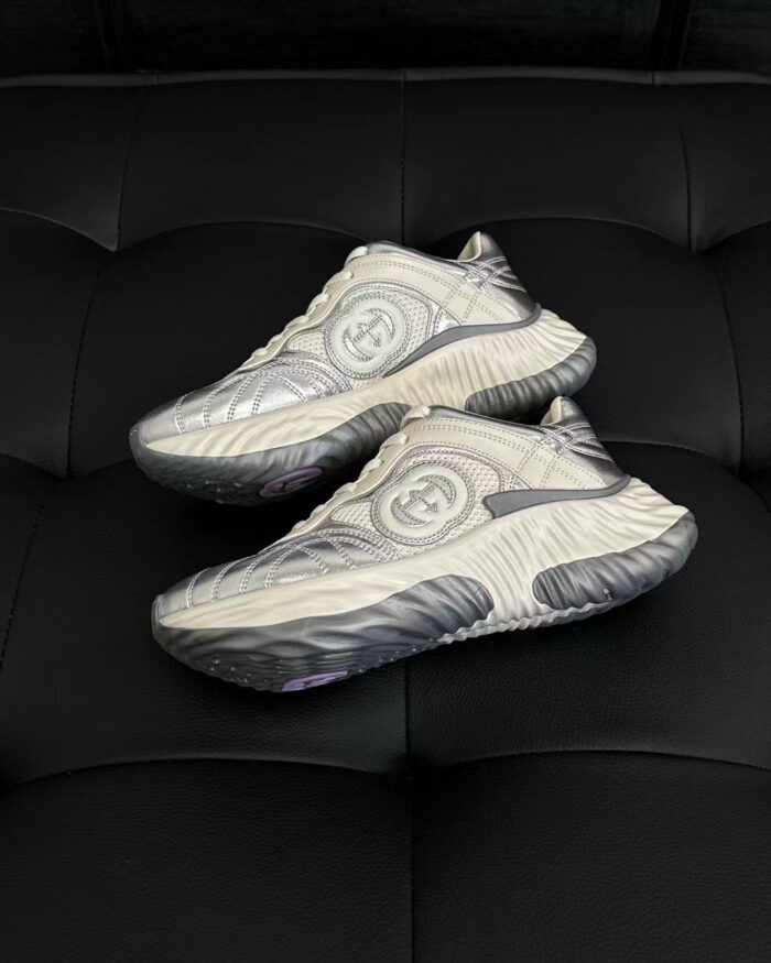 Sneakers futuristiche con logo collaborativo, design elegante, su superficie nera per un look moderno.