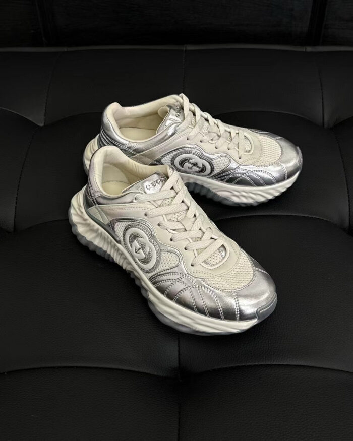 Sneakers moderne di lusso con dettagli metallici e design sporty su sfondo nero elegante.