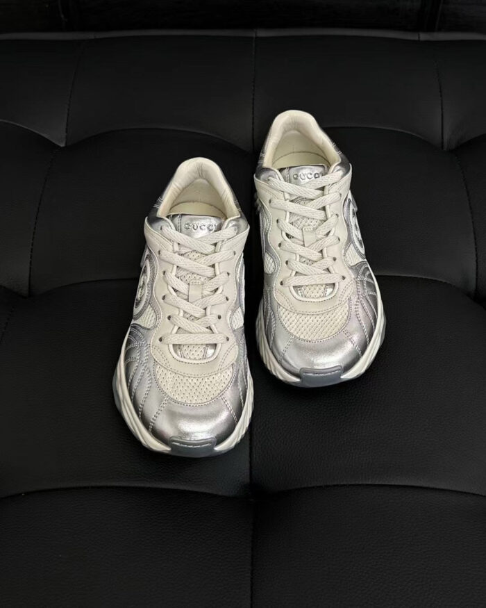Scarpe sportive moderne bianche con dettagli riflettenti e suola antiscivolo su sfondo nero.