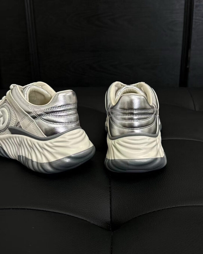 Sneakers bianche moderne con dettagli silver, suola chunky e design dinamico e futuristico.