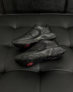 Scarpe sportive nere su superficie tessuta elegante, stile moderno e massimo comfort.