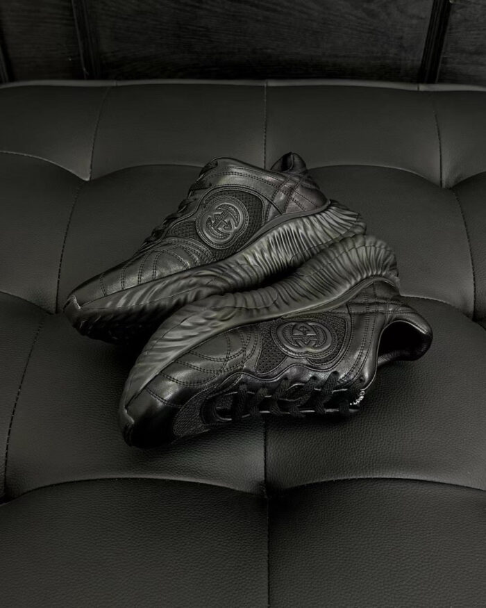 Sneakers nere moderne con logo circolare e design elegante su sfondo in velluto.