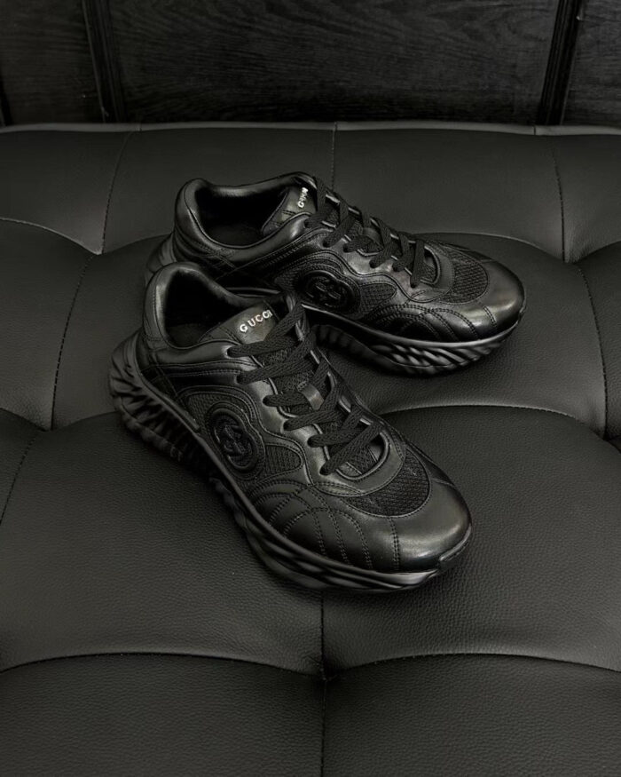 Sneaker nere moderne con suola wavy, dettagli in mesh e stile urbano versatile.