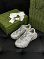 Sneaker di lusso bianche con dettagli eleganti, accanto a borsa raffinata e stile moderno.