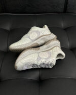 Sneakers bianche moderne in pelle con dettagli eleganti e suola trasparente, stile e comfort garantiti.