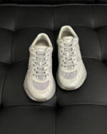 Scarpe sportive grigie moderne su sfondo nero, dettaglio di design e comfort.
