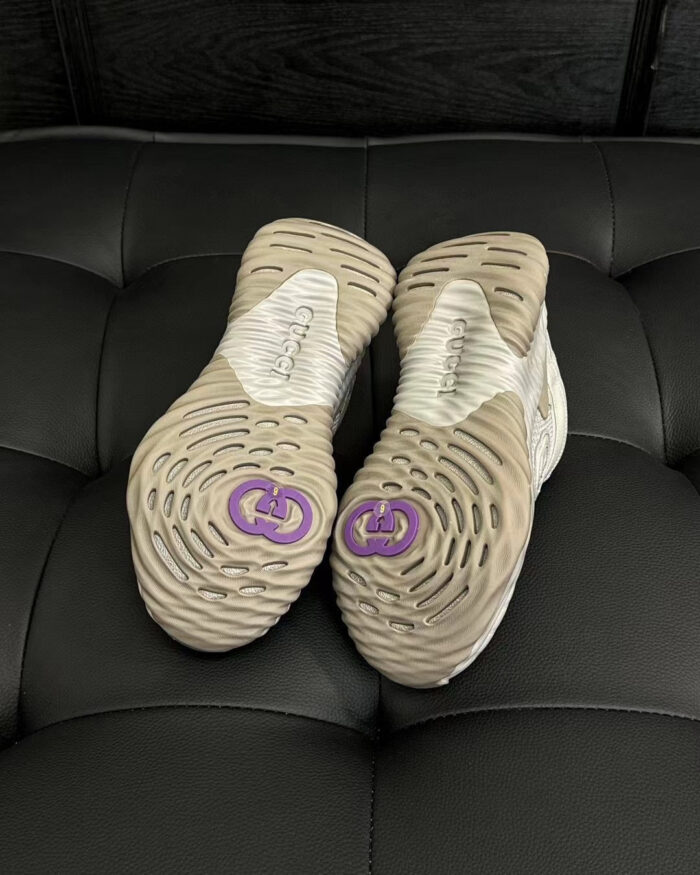 Scarpe da corsa con suola beige e logo viola, design elegante e funzionale.